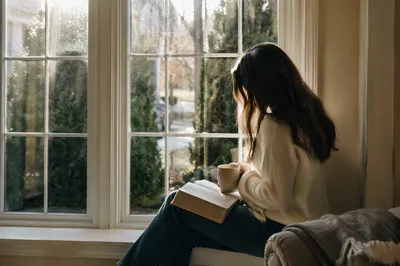 Woman Reading Bible by Winter Window