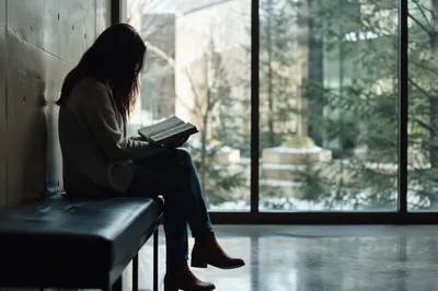 Woman Reading Bible by Winter Window