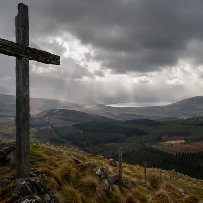 Weathered Cross on Hilltop Under Stormy Sky