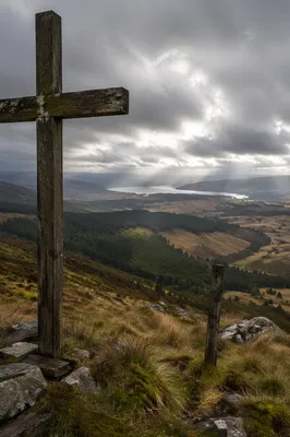 Weathered Wooden Cross Above Stormy Valley