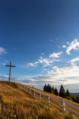 Wooden Cross on Hilltop Beneath Dramatic Sky