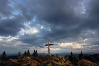 Wooden Cross on Hilltop Under Stormy Sky