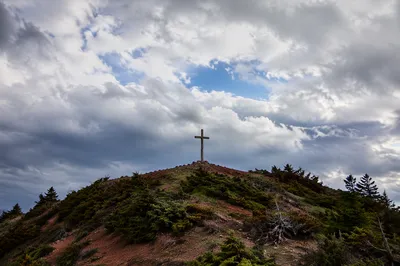 Wooden Cross on Rugged Hilltop Sky