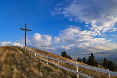 Wooden Cross on Hilltop Under Dramatic Sky