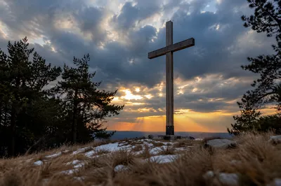 Wooden Cross on Windswept Evergreen Hilltop