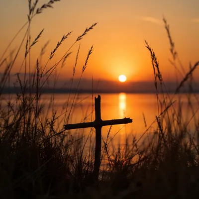 Rustic Wooden Cross at Sunrise Lakeshore