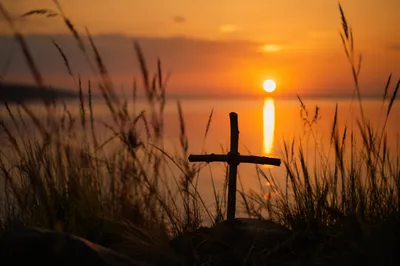 Rustic Wooden Cross at Sunrise Lakeshore