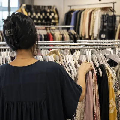 Shopper Browsing Clothing Rack in Boutique