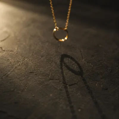 Elegant Gold Pendant Shadow Still Life