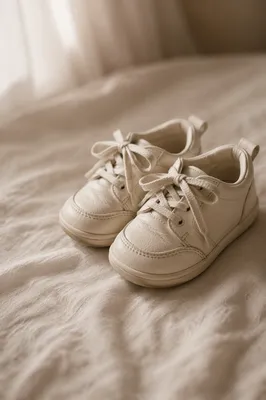 Cream Toddler Sneakers on Soft Bedspread