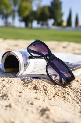 Glossy Black Sunglasses on Summer Sand