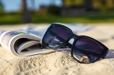 Glossy Black Sunglasses on Summer Sand