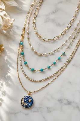 Layered Gold Necklaces on White Marble