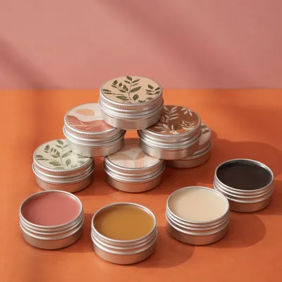 Organic Lip Balm Tins on Orange Table