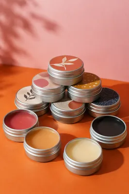 Organic Lip Balm Tins on Orange Table