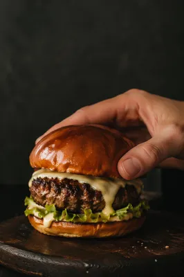 Gourmet Restaurant Burger Close-Up with Hand