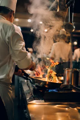 Chef Flambe in Busy Restaurant Kitchen