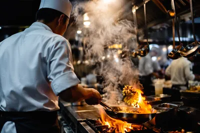 Chef Flambe in Busy Restaurant Kitchen