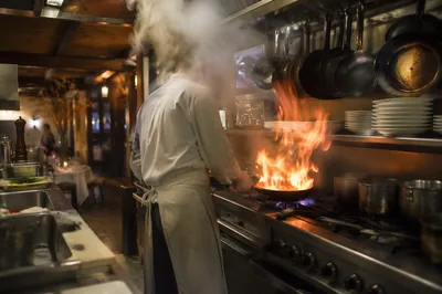 Chef Cooking Over Flame in Restaurant