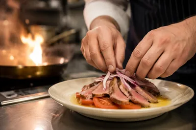 Chef Finishing Gourmet Dish by Kitchen Fire