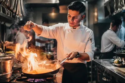 Chef Sautéing with Flare in Kitchen