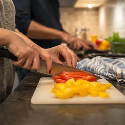 Hands Slicing Peppers in Cozy Kitchen