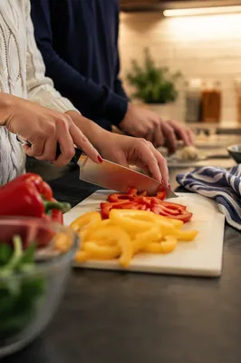 Hands Slicing Bell Peppers in Cozy Kitchen