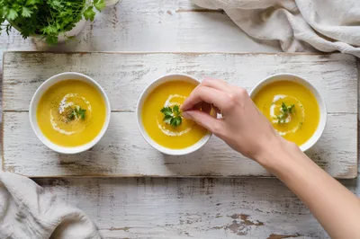 Homemade Golden Soup Garnished in Bright Kitchen