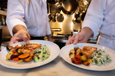 Commercial Kitchen Hands Serving Prepared Plates