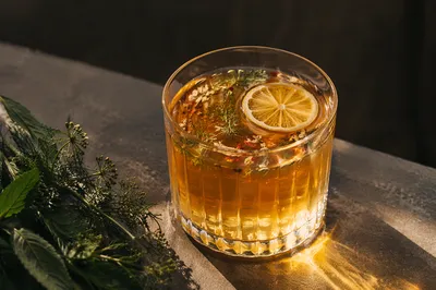 Amber Herbal Cocktail with Citrus Garnish