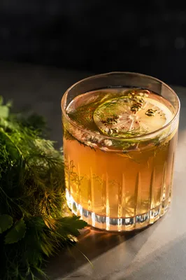 Amber Herbal Cocktail with Citrus Garnish