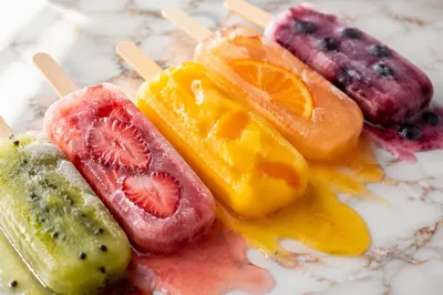Melting Colorful Fruit Popsicles on Marble