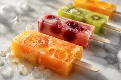 Colorful Melting Fruit Popsicles on Marble