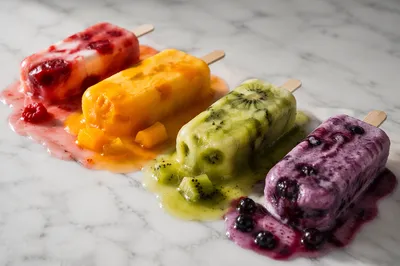 Melting Fruit Popsicles on White Marble