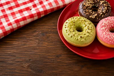 Colorful Glazed Donuts on Rustic Wooden Table