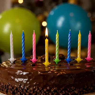Lit Candle on Chocolate Birthday Cake