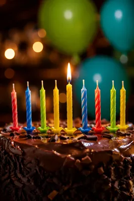 Lit Candle on Chocolate Birthday Cake