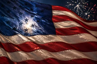Patriotic Fireworks Behind Waving Flag Banner