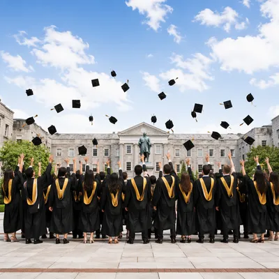 Graduates Tossing Caps in University Courtyard