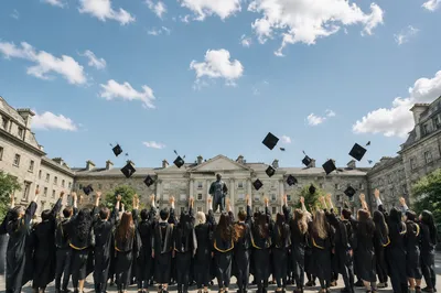 Graduates Tossing Caps in University Courtyard