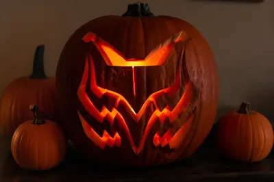 Glowing Carved Pumpkin on Autumn Table