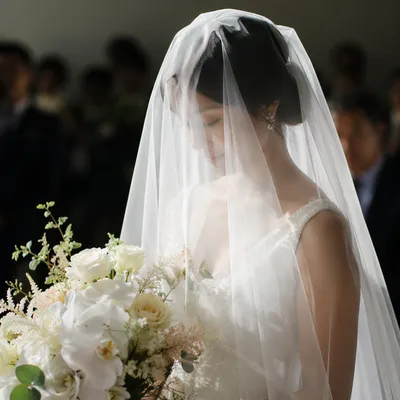 Veiled Bride Holding White Wedding Bouquet
