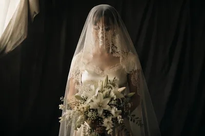 Veiled Bride Holding White Lily Bouquet