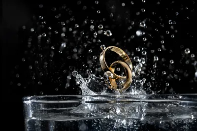 Elegant Gold Wedding Rings Splashing in Water