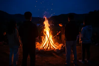 Night Campfire Gathering on Grassy Hillside
