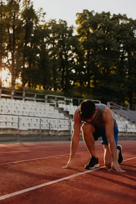 Athlete Kneeling on Sunrise Running Track