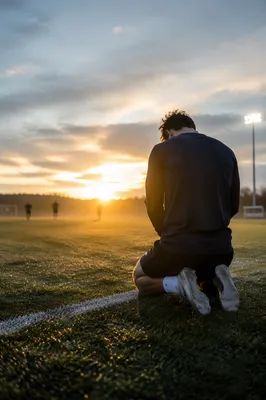 Athlete Kneeling in Prayer at Sunrise