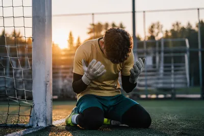 Goalkeeper Kneeling in Prayer at Sunrise