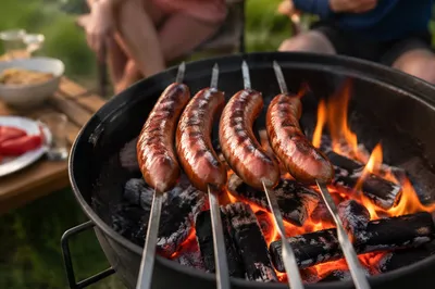 Family Barbecue Sausages Over Backyard Fire Pit