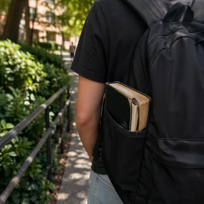 Bible in Backpack on Campus Walkway